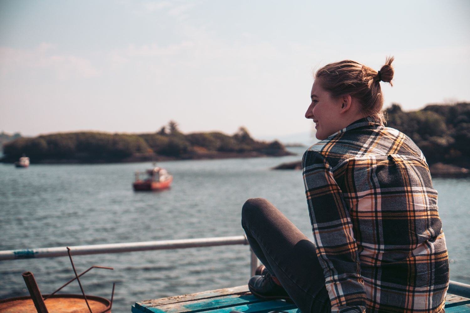 Ein Foto von einer Person die auf einem Steg sitzt und auf ein See schaut in Irland