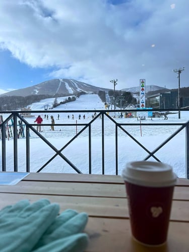 Eine Teilnehmende macht Pause beim AIFS Winter Work Japan Programm mit einem Kaffee im Schnee.