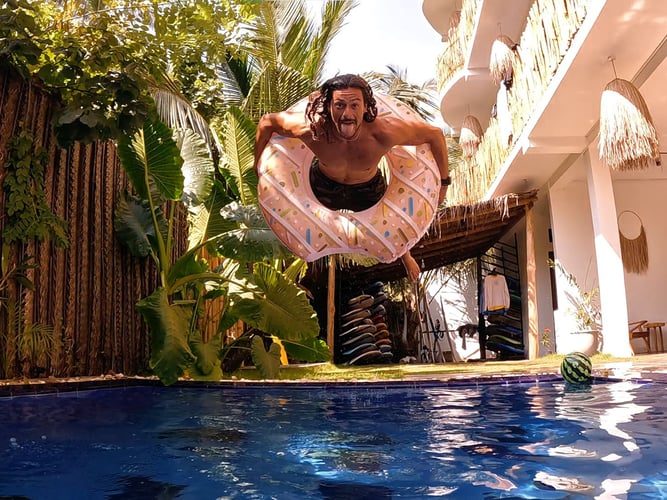 Person entspannt am hauseigenen Pool der Unterkunft im AIFS Surfcamp Sri Lanka.