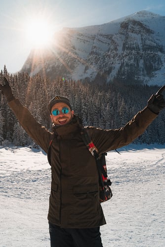 Erlebe Kanada mit AIFS: Person im Schnee vor beeindruckender Bergkulisse.
