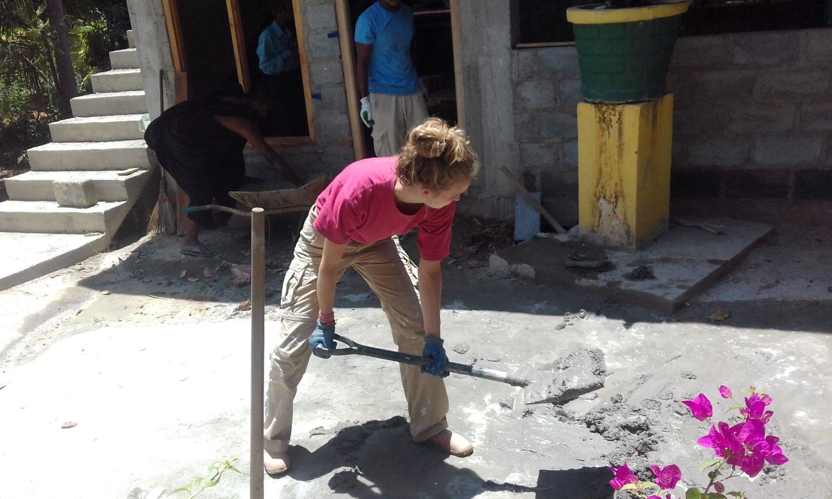Freiwilliger in Sri Lanka bei Bau- und Renovierungsarbeiten mit AIFS, arbeitet mit einer Schaufel.