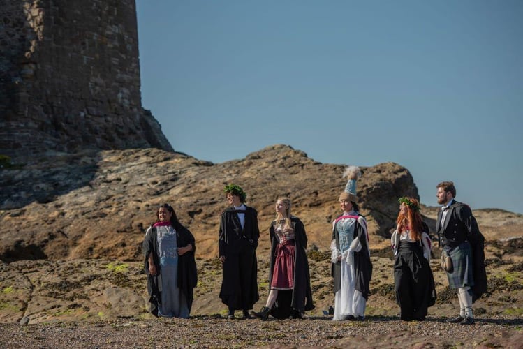 Studierende in Schottland in traditionellen Outfit am Strand